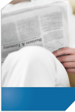 Person reading the business and economy section of the newspaper.